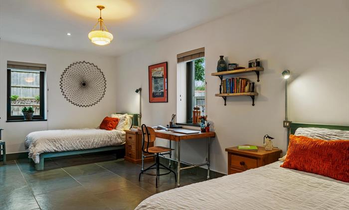 on the ground floor with twin single beds with bedside cupboards and lights, period pendant lamp shade, desk and chair for laptop/homeworking. Full un